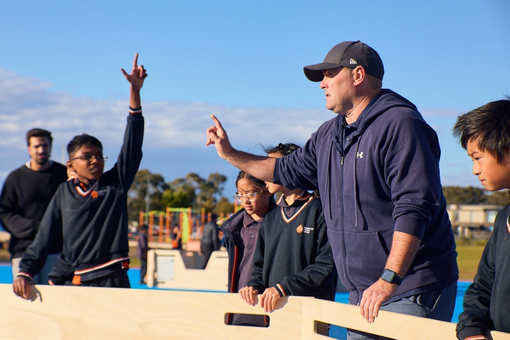 A PE teacher at school using a gaga games portable gaga pit for a lesson at school