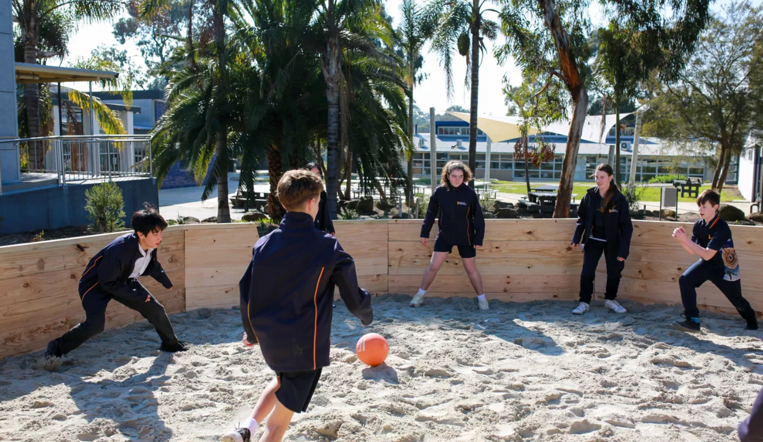 kids at school playing gaga ball in a gaga pit with tropical background